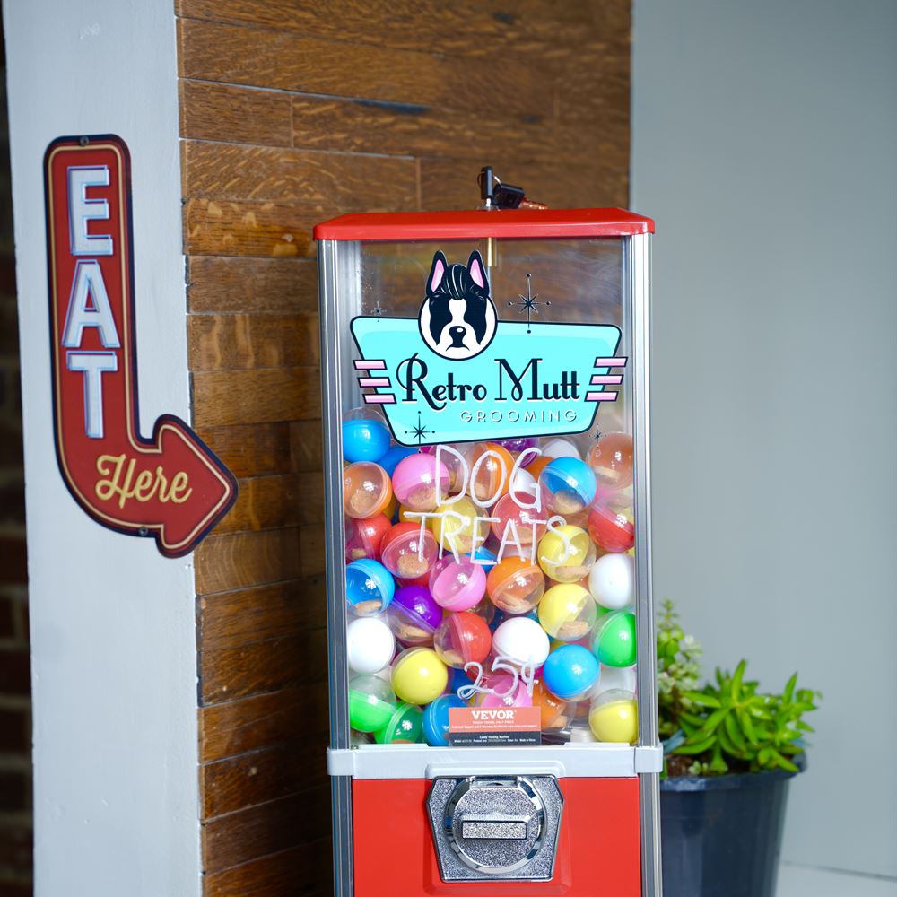 A red vintage gumball machine refilled with Retro Mutt dog treats at 25 cents a turn